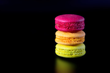 Colorful macarons on black background