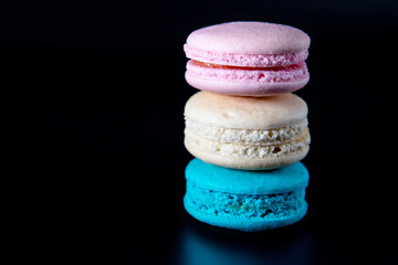Colorful macarons on black background