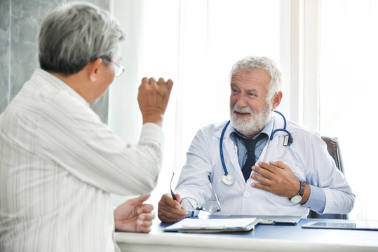 Senior male Doctor and Asian male patient are talking.