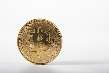 Golden bitcoin on isolated on white table. A visual representation of digital cryptocurrencies. Bitcoin are fully dematerialized and decentralized electronic currencies