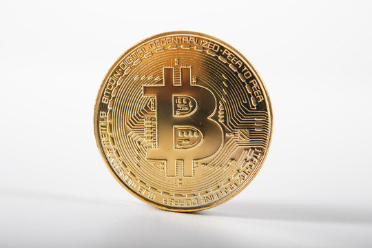 Golden bitcoin on isolated on white table. A visual representation of digital cryptocurrencies. Bitcoin are fully dematerialized and decentralized electronic currencies