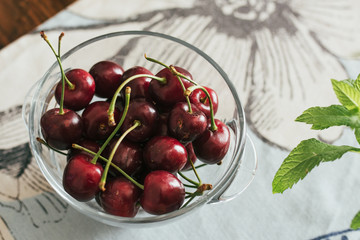 Ecological cherries in glass bowl, on the table