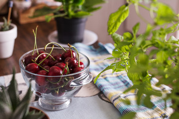 Ecological cherries in glass bowl, on the table