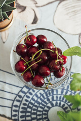 Ecological cherries in glass bowl, on the table