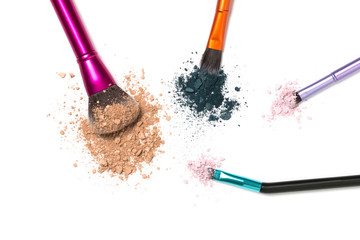 Face powder and eyeshadow with four brushes on white isolated background with copy space.