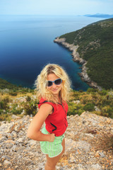 young beautiful girl standing on a cliff