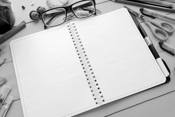 School accessories: pencils, pens, brushes, glasses, paints, buttons, notebook, notepad, chalk, paper and pot with cactus on a blue wooden background. Back to school