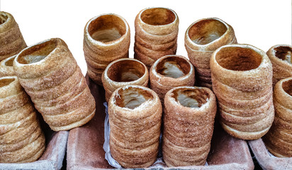 A counter with the Czech traditional street food-trdelnik isolated on white background. The photo of delicious trdelniks, - spit cake, grilled and topped with sugar, was shot on a street of Prague.