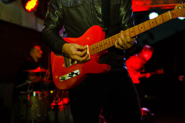 Obraz na płótnie Canvas Closeup photo of bass guitar player hands, soft selective focus, bright live music theme