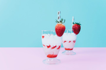 Milkshake with straw and strawberry.