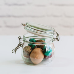 Quail easter painted eggs in glass jar.