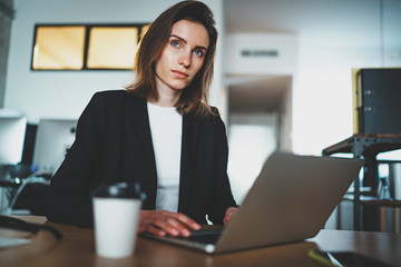 Beautiful Businesswoman using laptop computer at modern office.Blurred background.Horizontal.
