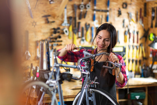 Young woman working in a bicycle repair shop
