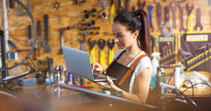 Young woman working in a bicycle repair shop
