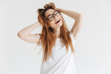 Cheerful woman in t-shirt and eyeglasses holding her hair