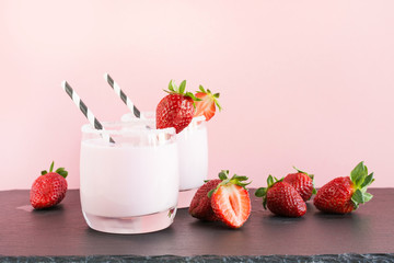 Strawberry milkshake with berry on pink. Close up. Summer drink.