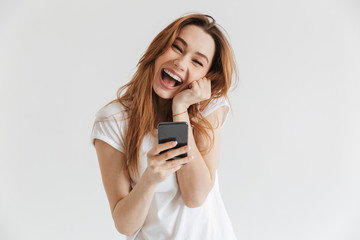 Naklejka premium Cheerful woman in casual clothes holding smartphone