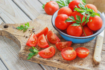 red tomatoes on a wooden board with parsley. country style