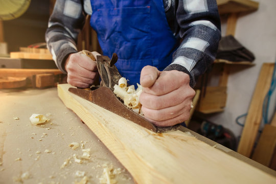 woodworker keeps in the hands of the plane, removes chips from the wood and aligns the timber