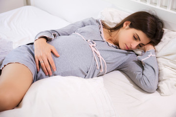 Pregnant woman sleeping peaceful in bed