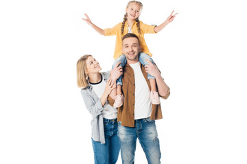 smiling father and daughter piggybacking with mother standing near by isolated on white
