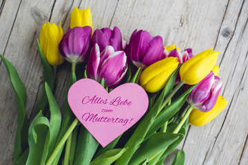 Greeting card - Pink and yellow tulips on a wooden background