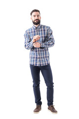 Fototapeta premium Confident smiling bearded business man getting dressed buttoning sleeve and looking at camera. Full body isolated on white background. 