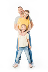 smiling parents and little daughter hugging each other and looking at camera isolated on white
