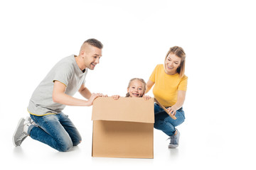 Fototapeta na wymiar happy parents and little daughter in cardboard box having fun together isolated on white