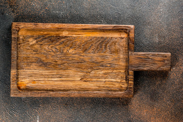 Old cutting board on dark wooden background copy space top view