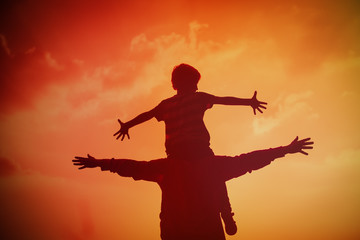Fototapeta na wymiar father and son play on sunset sky