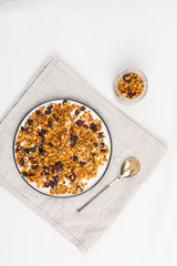 Homemade granola on plate (with dried fruit and nuts). Concept healthy breakfast  on white background. Top view.