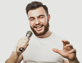 lifestyle and people concept: young man singing with microphone