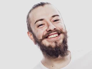 Obraz premium Lifestyle and people concept: Closeup portrait of a happy young man smiling on white background