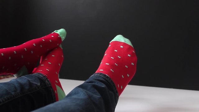 A pair in colorful socks caress each other for Christmas. Love of man and woman.