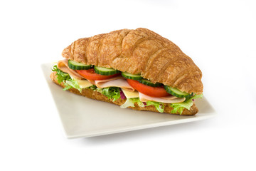 Croissant sandwich with cheese, ham and vegetables Isolated on white background