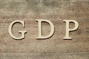 English alphabet in word GDP (Abbreviation of good distribution practice or gross domestic product) on wood background