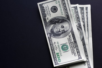One hungret dollar bills on black background. Cope space