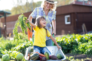 Mother playing with kid daughter in garden in village