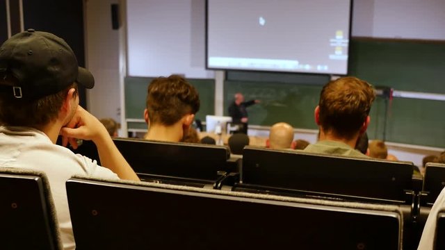 Professor or teacher delivers a lecture college to a large audience of students 