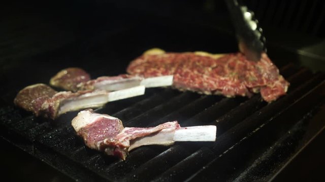 Chef flipping grilled Lamb ribs and beef steak 4K
