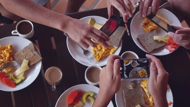 A group of men take pictures of their breakfast on the phones, top view. Slow motion. HD, 1920x1080