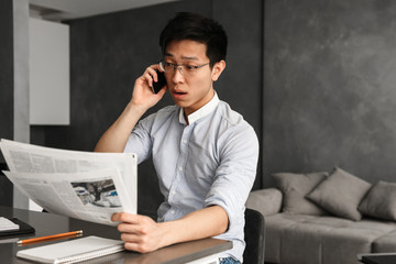 Fototapeta na wymiar Emotional young asian man talking by phone