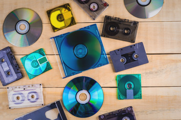 Music cassettes and music CDs lie on a wooden table