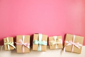 Simple composition with multiple presents wrapped in hand made blank craft paper gift wrap, pastel...