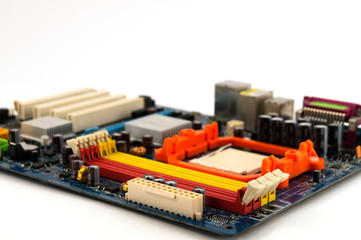 Motherboard for computer, located at an angle with a blurry background on a white background.