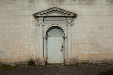 abandoned door with a stone arch against a stone wall background