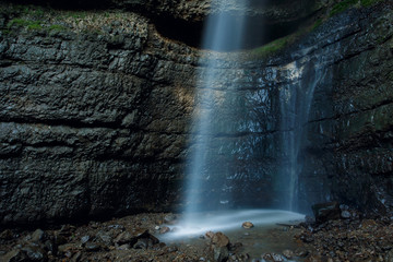 Fototapeta na wymiar A stream of waterfall falling from a rock