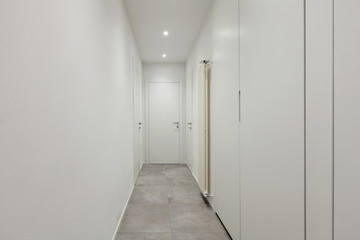 Corridor all white with tiles on the floor