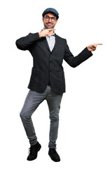 Handsome modern man with beret and glasses pointing finger to the side and presenting a product